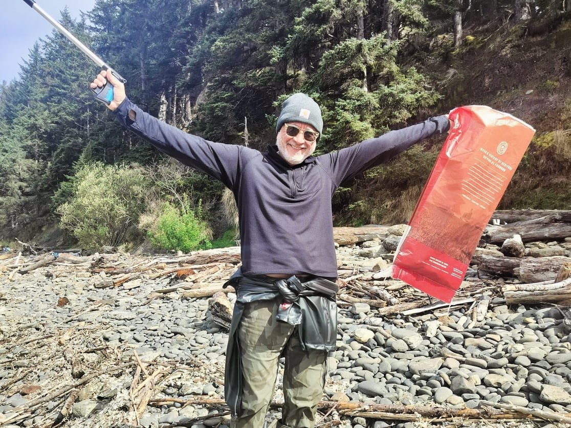 a man throws his hands up for joy at a beach cleanup
