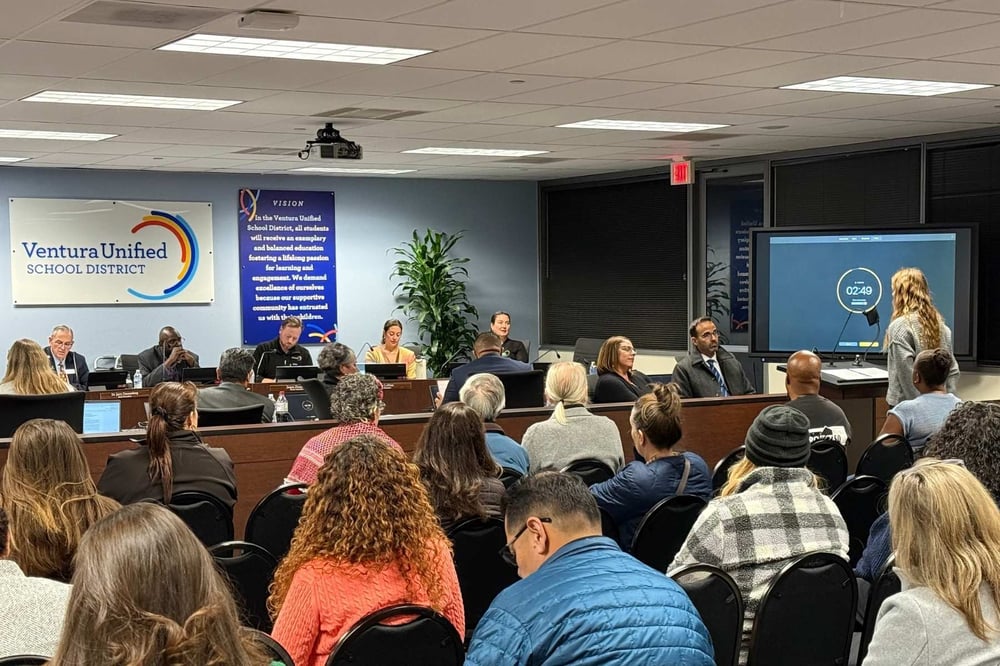 Bea speaks in front of a panel at a Ventura Unified School District assembly.