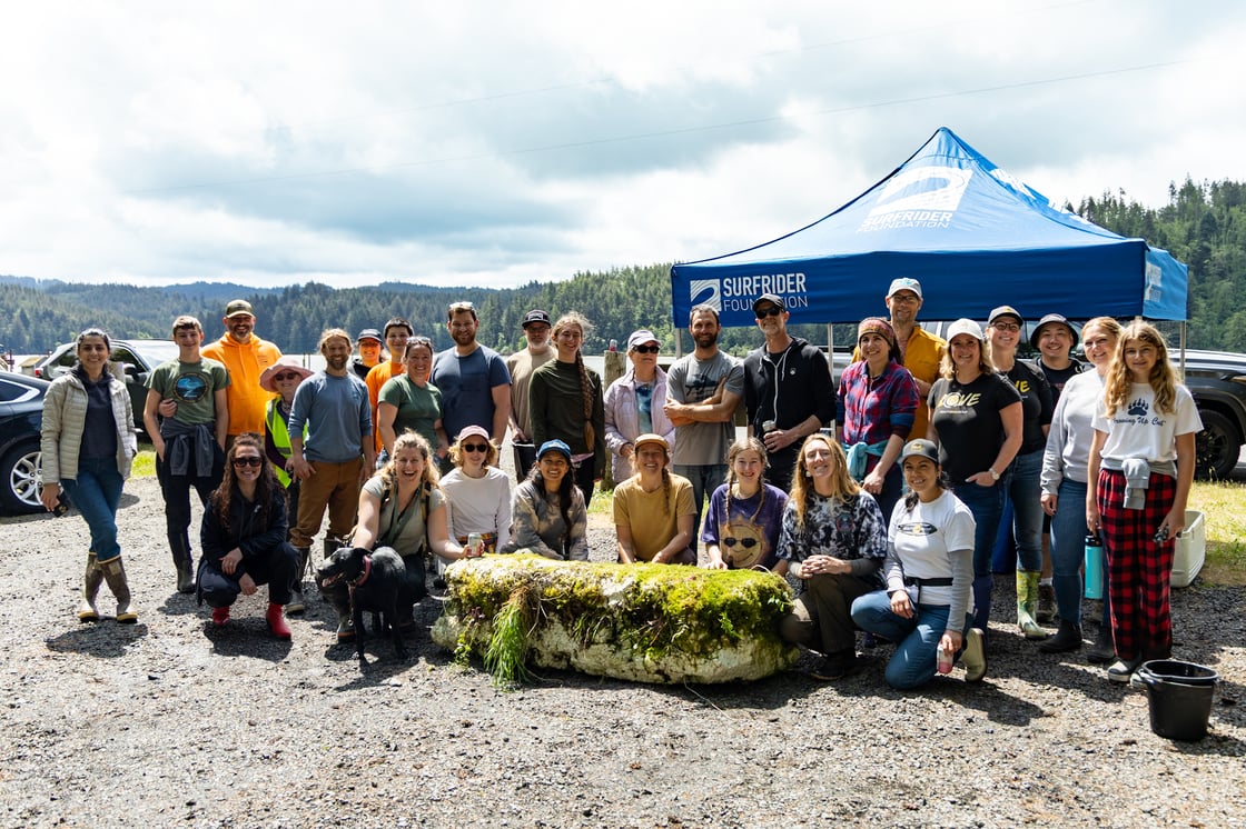 a group of volunteers pose with a huge chunk of styrofoam dock covered in algae, which was recovered from Yaquina Bay