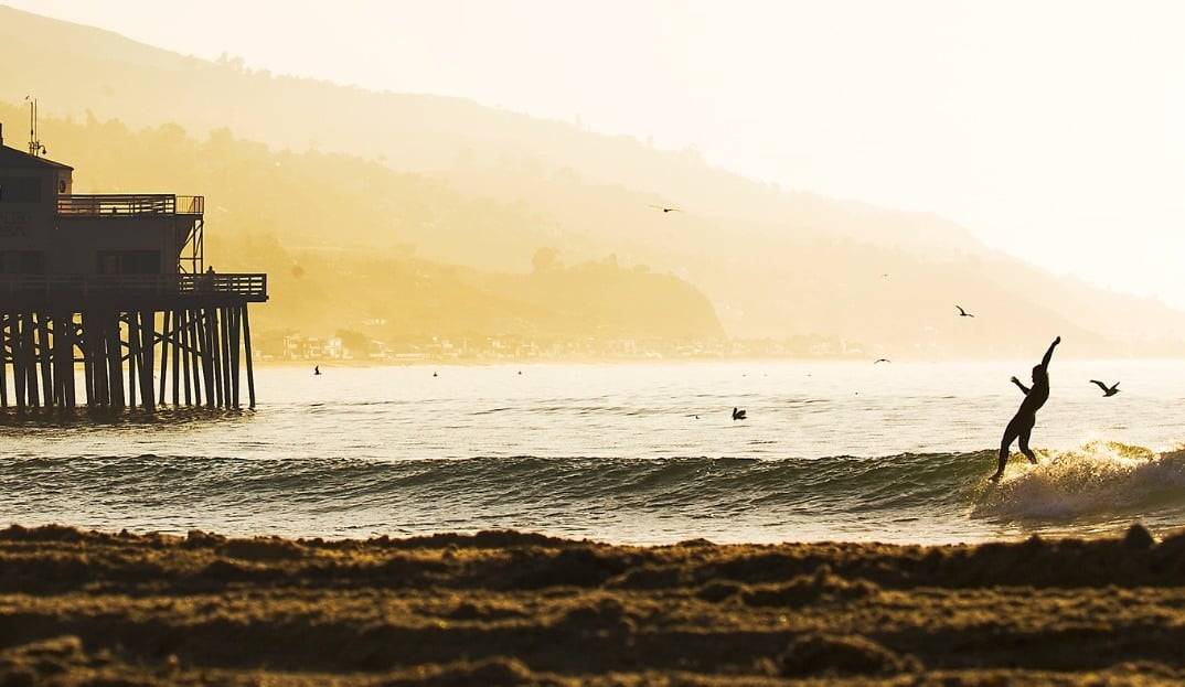 A silhouette of a surfer on a peeling wave at Malibu.