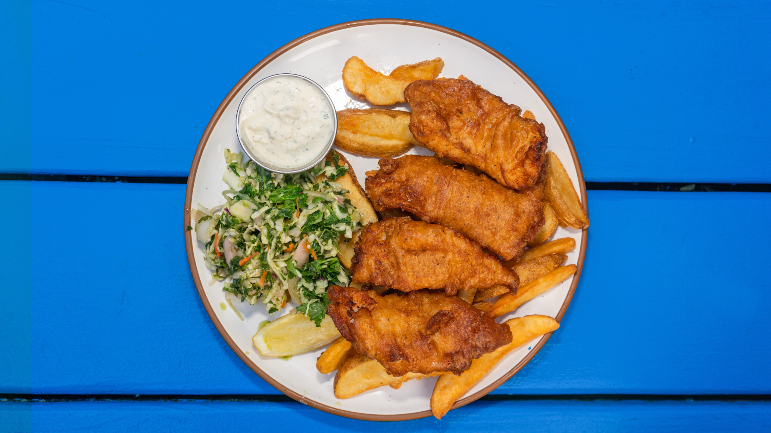 A plate of fish and chips shot from above.
