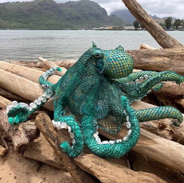 Blue/green octopus made out of fishing lines and other trash items.