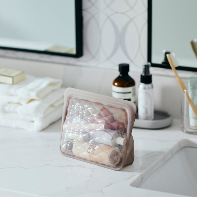 Soft purple Beauty Bag with cosmetics inside, on a counter top.