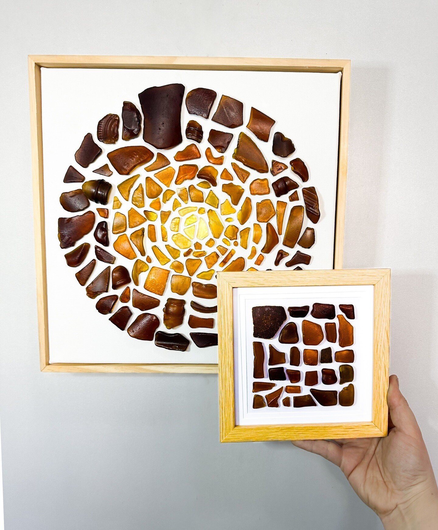 A circle made out of brown and yellow pieces of seaglass.