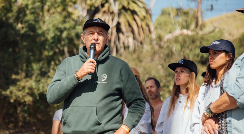 Shaun Tomson speaks to activists at the Paddle Out to Protect Our Coast event