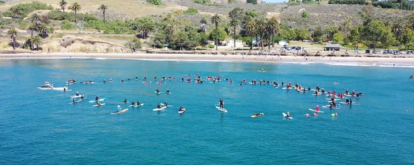 Volunteers paddle out at the Paddle Out to Protect Our Coast event at Refugio Beach in California