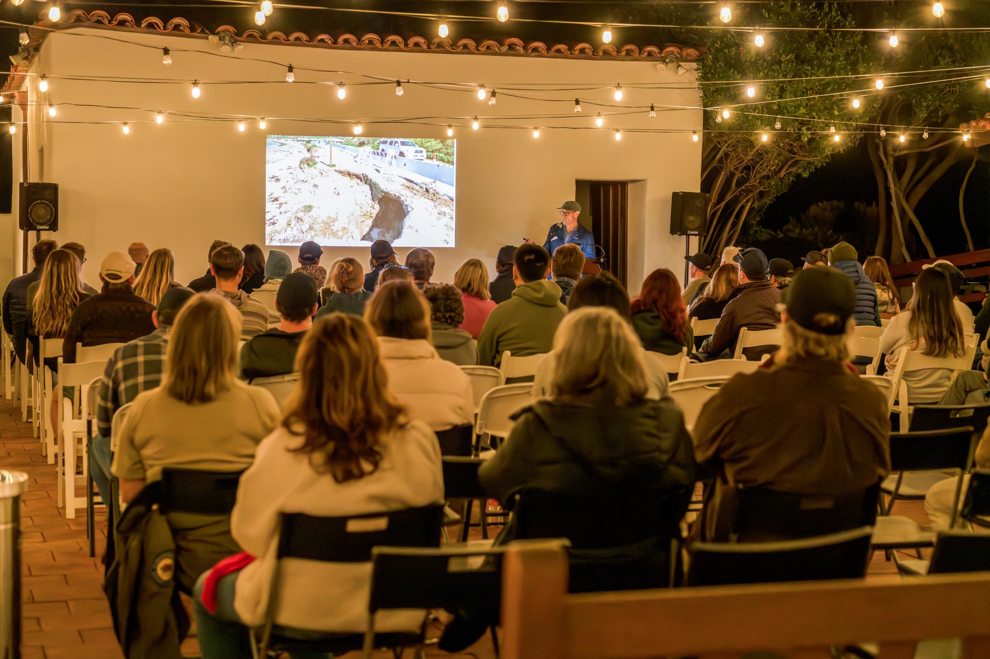 Attendees watch Sr. Environmental Scientist for CA State Parks, Dr. Riley Pratt shares an updated on recent beach conditions.