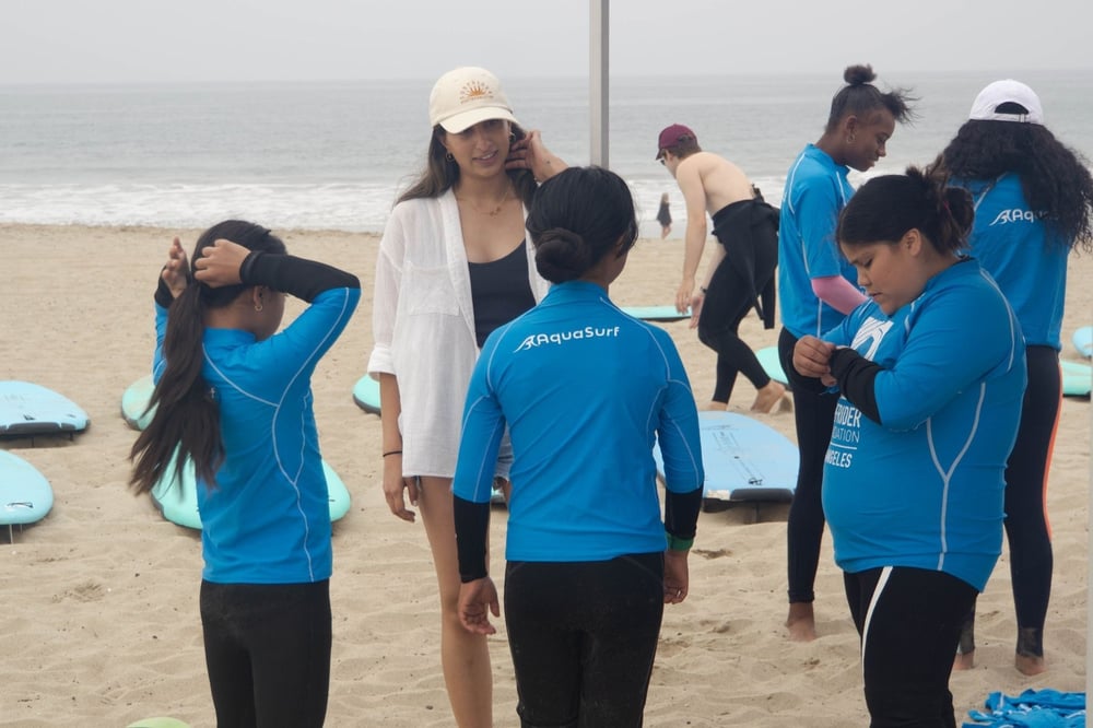 Tatiana under a Surfrider tent speaks with three participants of the One Watershed program.