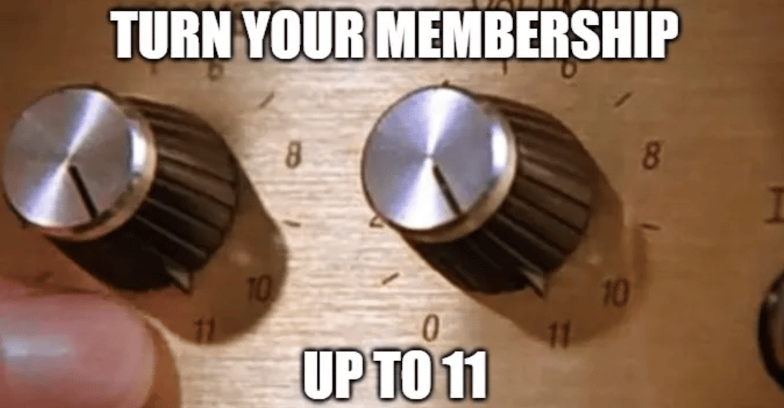 A close up of a hand turning a dial that reads "Turn your membership up to 11"