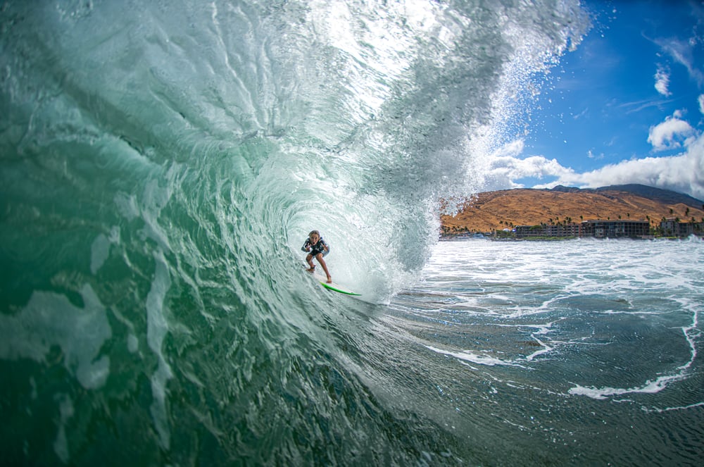 surfer pulls into a right hand barrel shot from in front.
