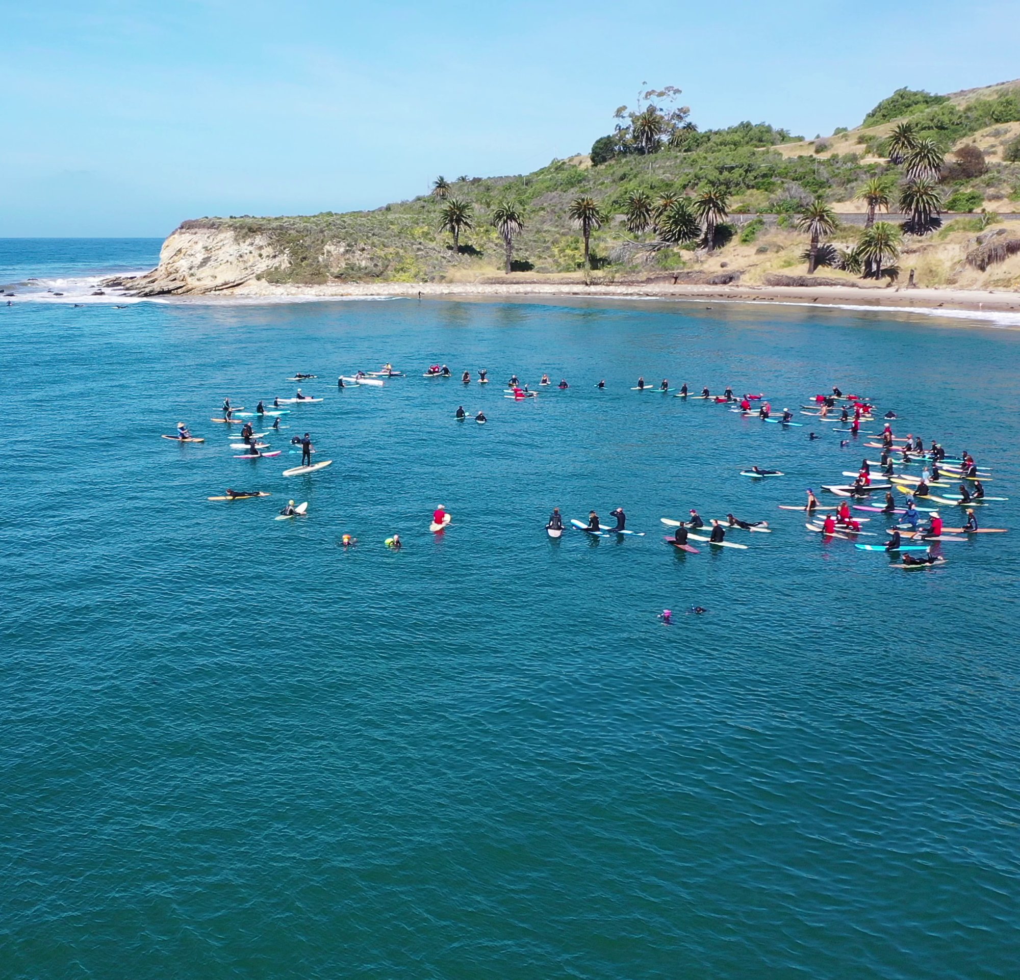 Surfers circle up for a paddle out