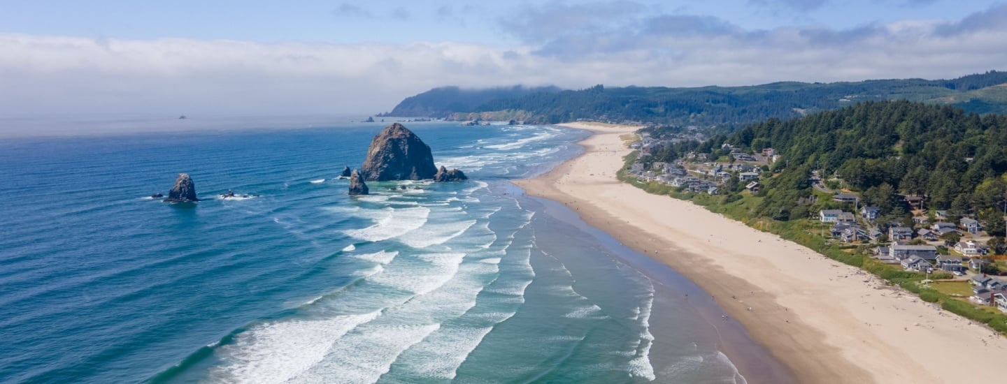 Aerial photo of Cannon Beach coast with Haystack Rock in the ocean.
