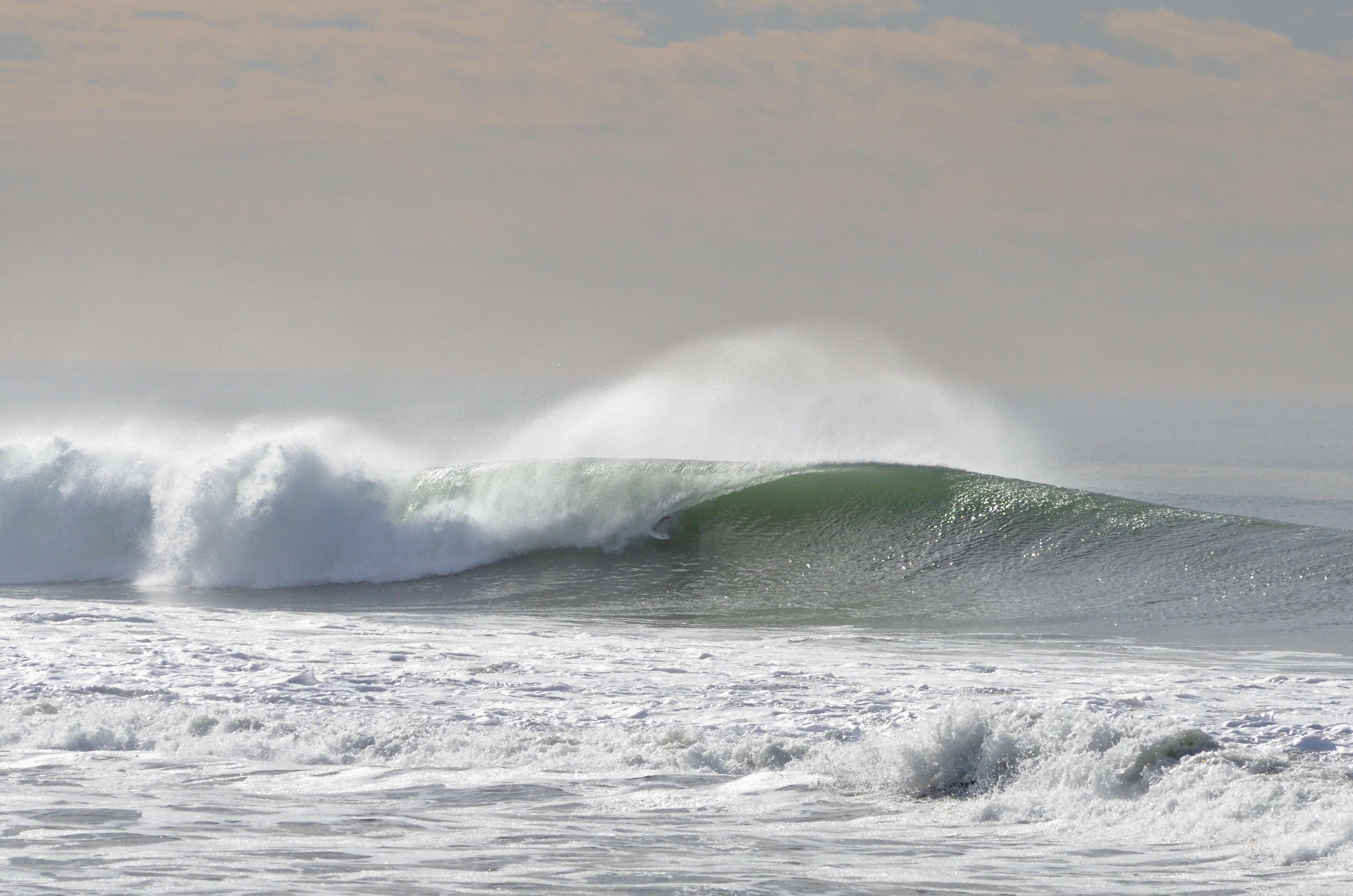A surfer pulls into a lefthand tube at Bolsa Chica