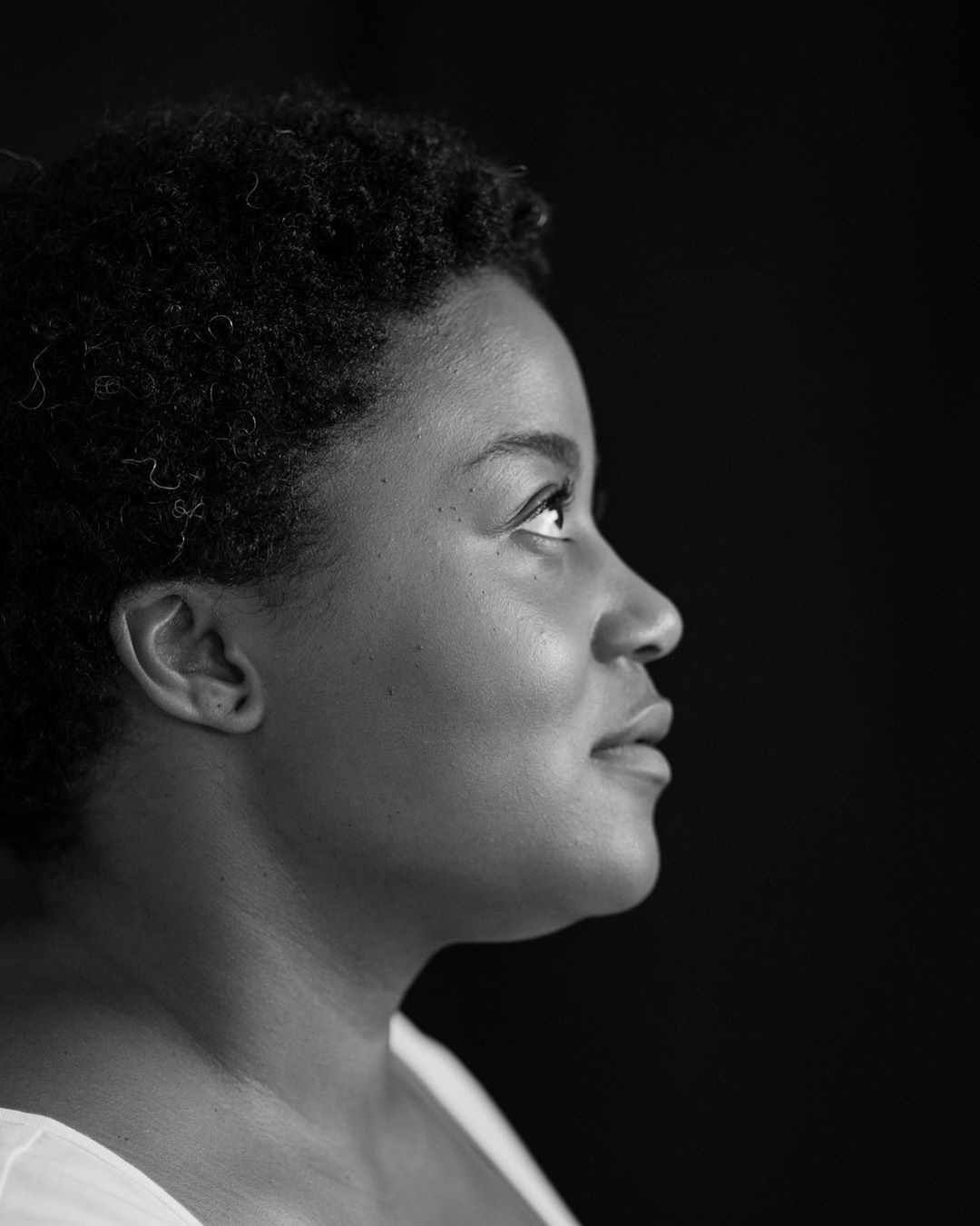 A black-and-white photography of Briana, a profile view with her looking to the right.