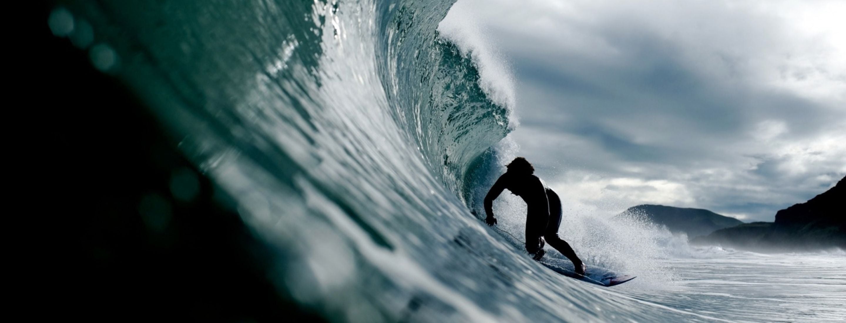 A surfer pulls into a barrel.