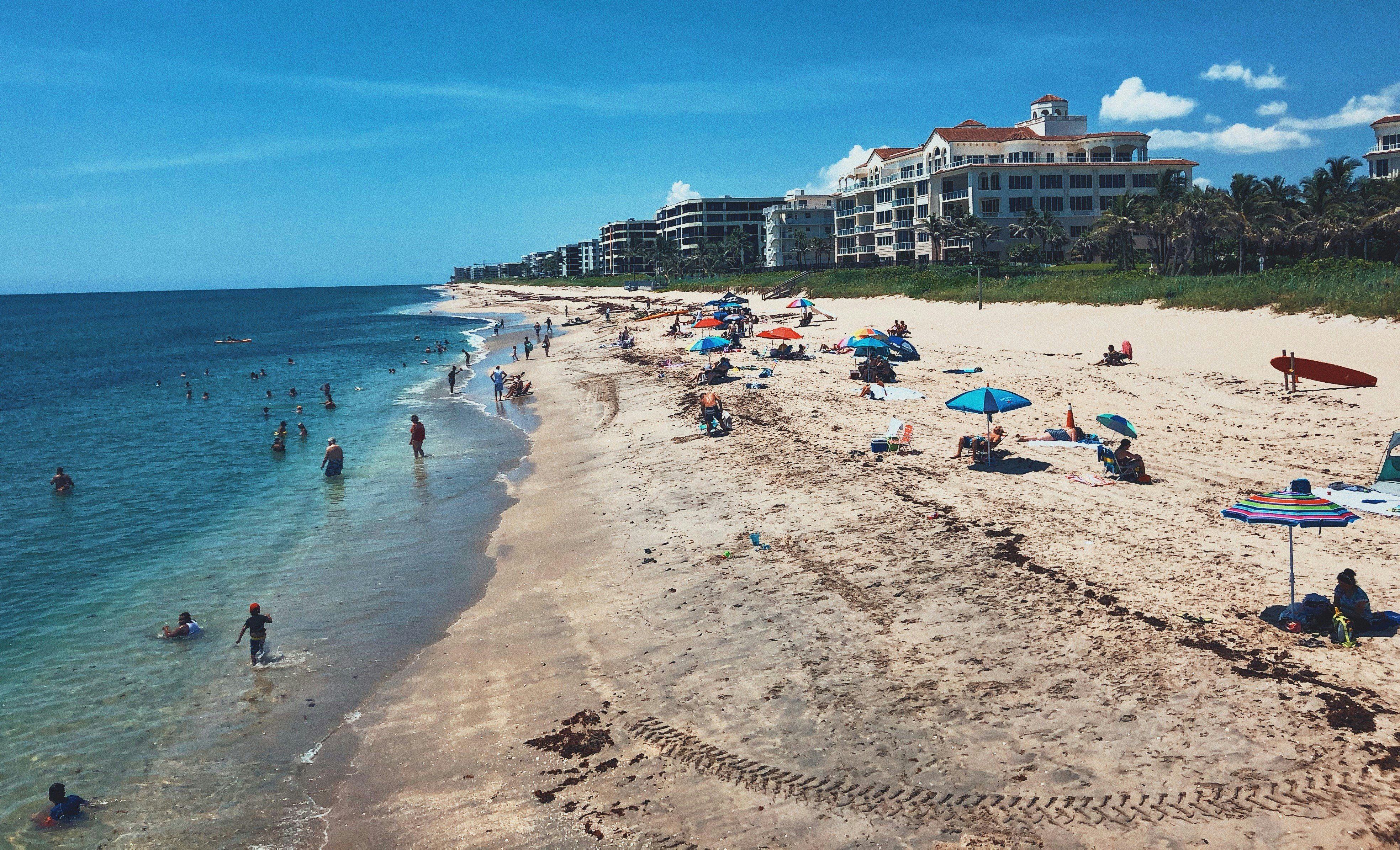 People on the beach in Palm Beach County. Image Credit: Tom Locke via Unsplash.