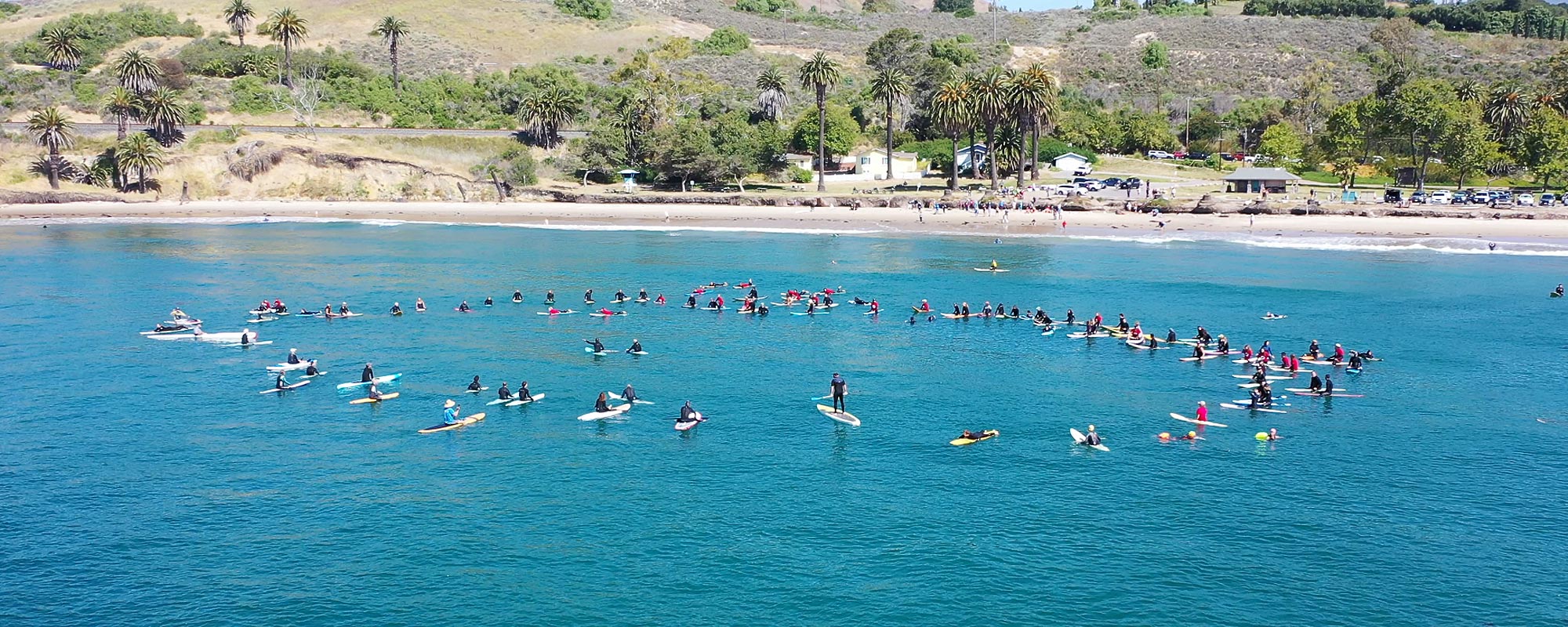 Volunteers paddle out at the Paddle Out to Protect Our Coast event at Refugio Beach in California